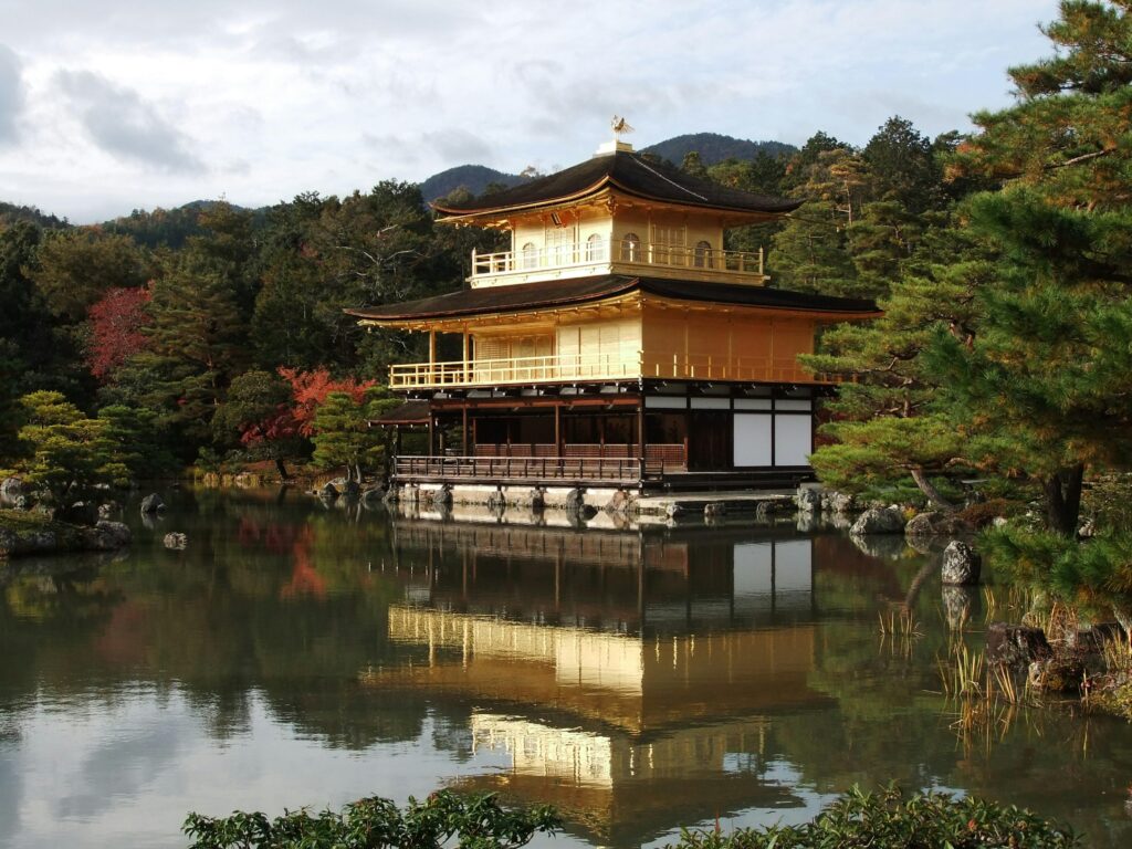 Ancient temple in Kyoto surrounded by lush greenery, featuring traditional Japanese architecture with intricate wooden details, ornate roof tiles, and serene, tranquil atmosphere.
