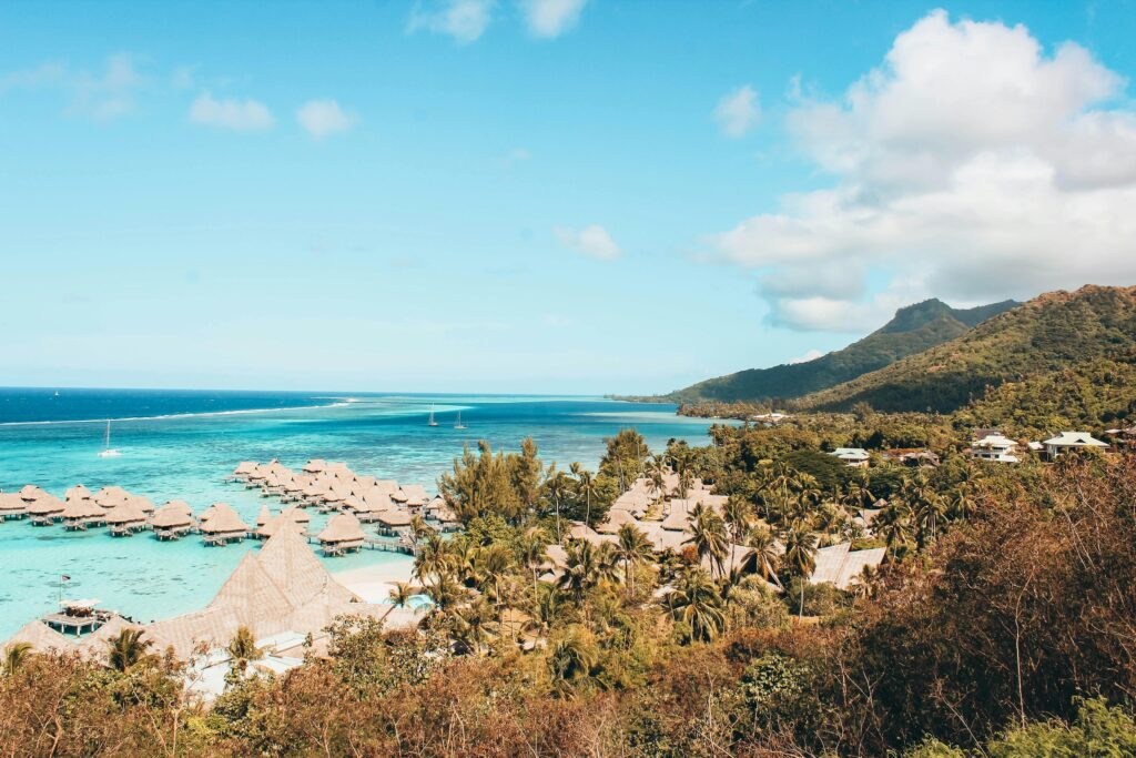 Tropical beach in Bora Bora featuring crystal-clear turquoise waters, soft white sand, and luxurious overwater bungalows, creating an idyllic setting at one of the world’s premier couples resorts, perfect for a romantic getaway.